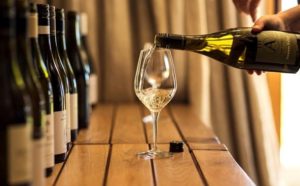Types of wine Bottles on either side and glass of wine in center